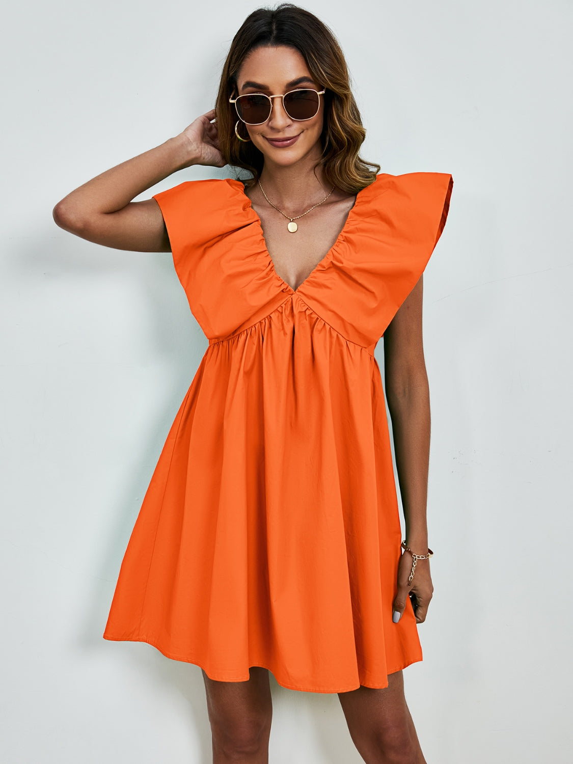 Sienna - Robe mini à col en V avec manches cape et jupe évasée en couleur unie vive